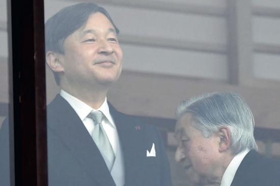 2018年12月23日，日本首都东京，明仁天皇（右）从皇太子德仁身后走过。当日是明仁天皇85岁生日。图/新华