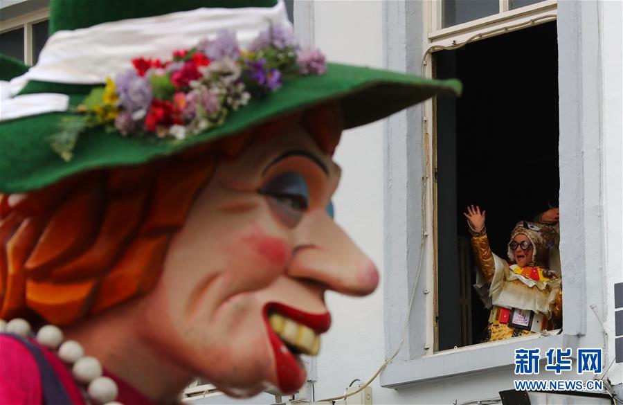 打个招呼　2月26日，在比利时小城阿尔斯特，一名观众观看阿尔斯狂欢节游行时挥手。 记者 龚兵/摄