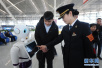 机器人服务春运：青岛北站工作人员向旅客介绍问询机器人“小路”
