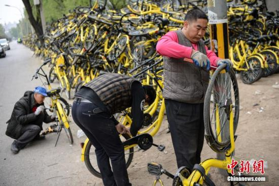 资料图：工作人员正在修理仍可修复的单车。 <a target='_blank' href='http://www.chinanews.com/'>中新社记者 崔楠 摄