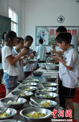  资料图：广西贫困县南宁上林县大丰镇总后希望小学，学生们在食堂享用营养午餐。黄艳梅 摄 